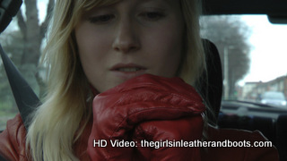 Girl-driving-car-in-red-leather-gloves-and-jacket