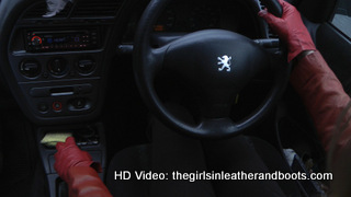 Girl-driving-car-in-red-leather-gloves-and-jacket