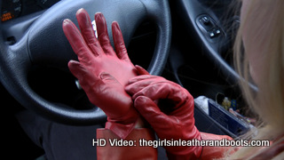 Girl-driving-car-in-red-leather-gloves-and-jacket