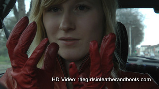 Girl-driving-car-in-red-leather-gloves-and-jacket